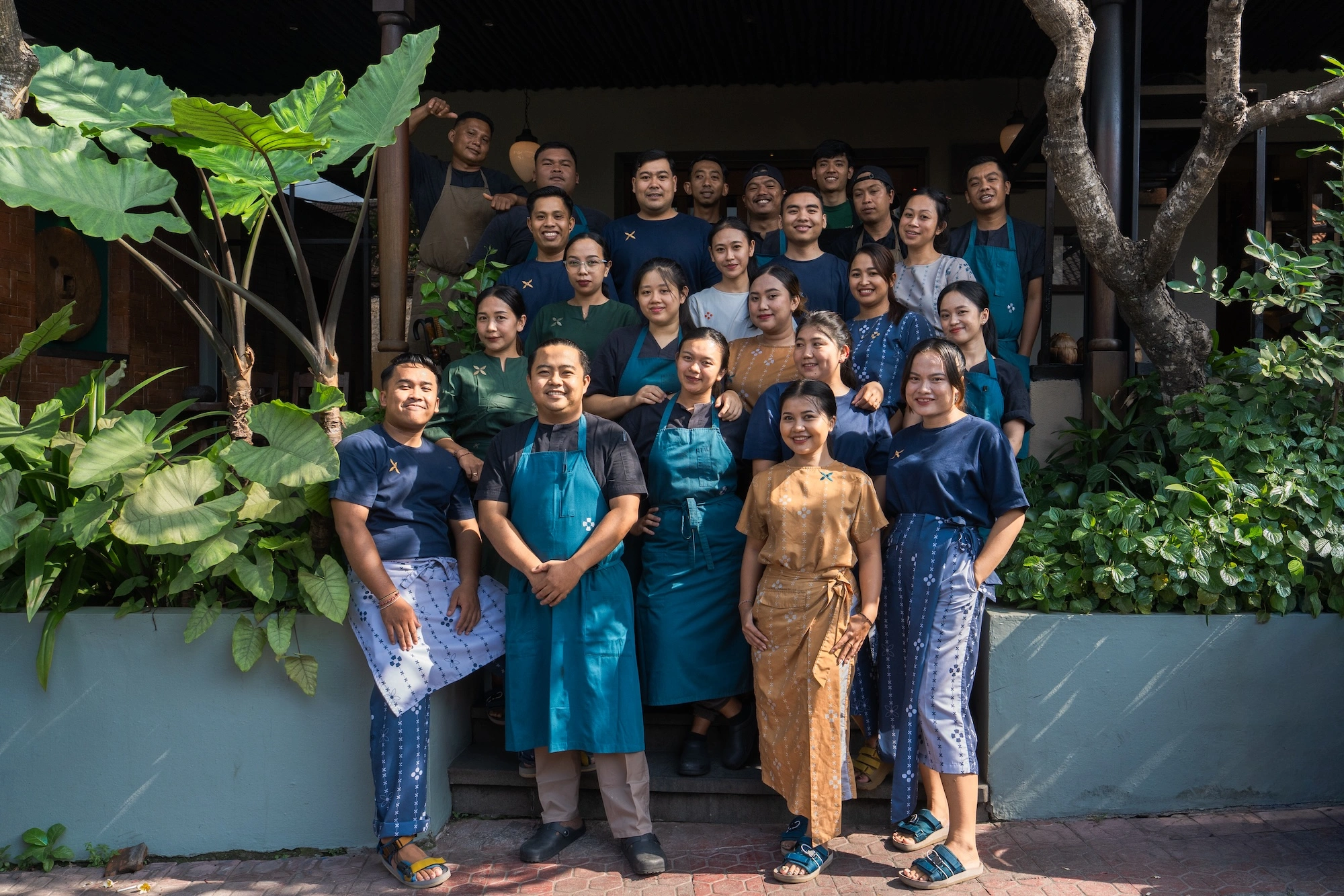 The whole Nusantara team gathered on the front steps of the restaurant, among the garden plants