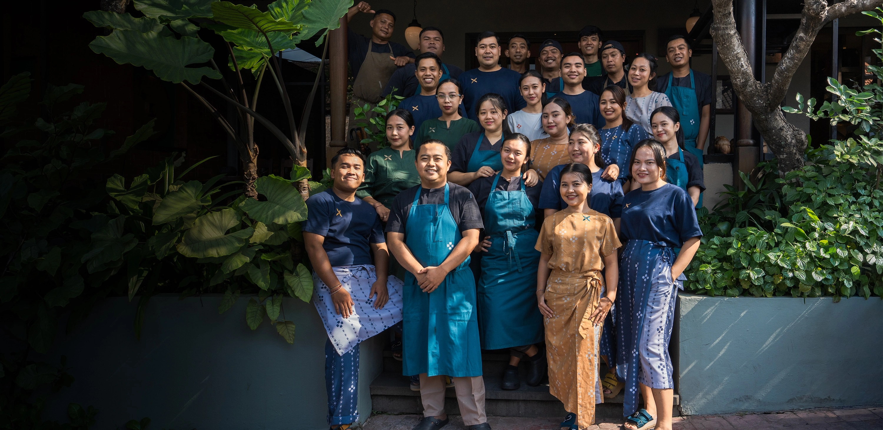 The whole Nusantara team gathered on the front steps of the restaurant, among the garden plants